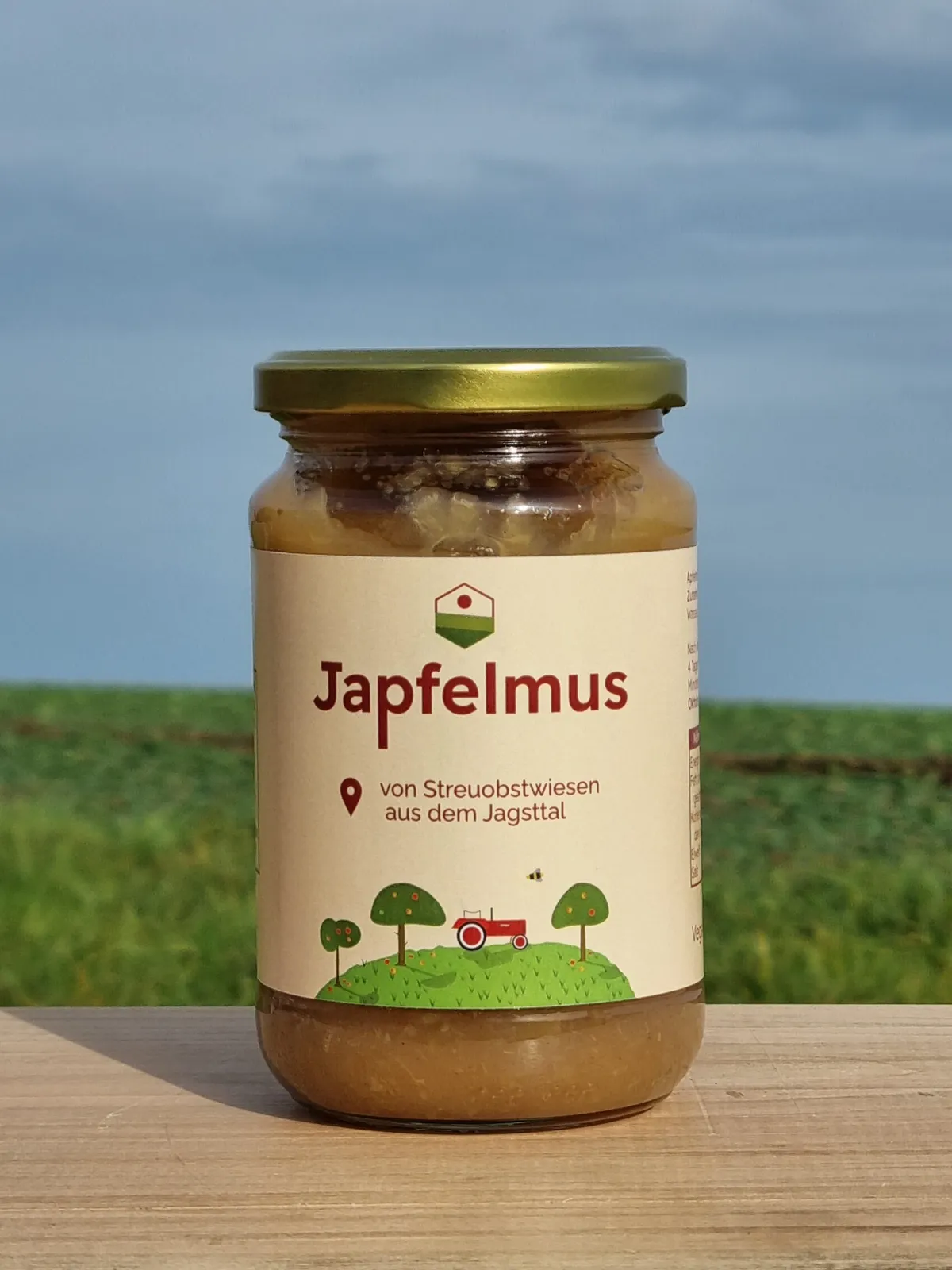 Ein Glas Japfelmus aus Brettacher Äpfeln auf einem Holzbrett